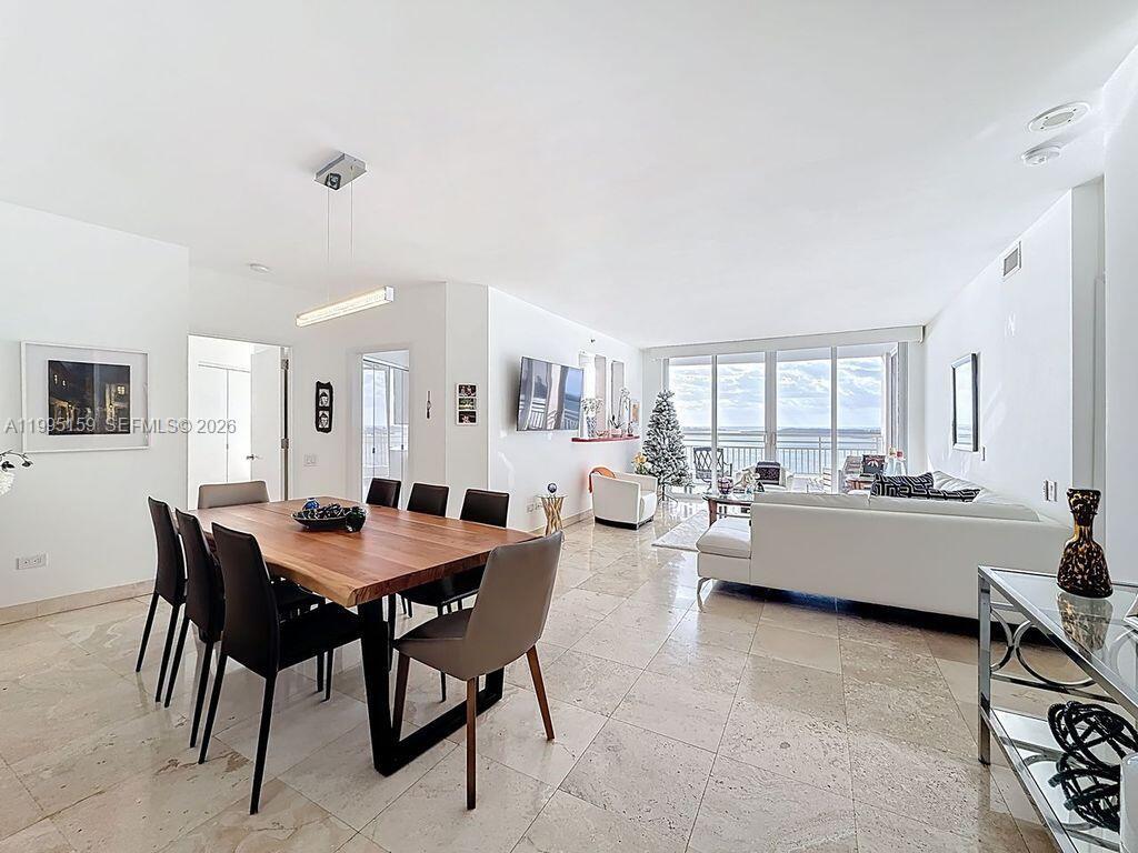 A dining area and living room with tile floors, white walls, and a balcony view — 808 Brickell Key Dr # 2002, Miami FL 33131, MIAMI, FL