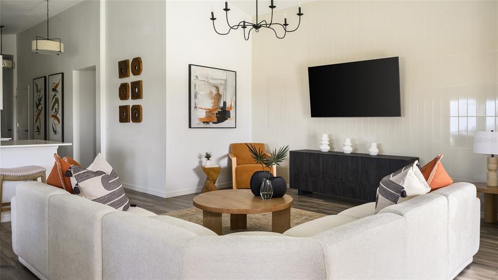 A living room features a large sectional sofa, a round coffee table, and a wall-mounted television — 9273 JOYFUL HEIGHTS WAY, DADE CITY, FL