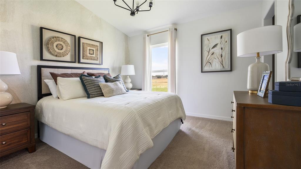 A bedroom features a queen bed, two nightstands, a dresser, and a window with curtains — 9273 JOYFUL HEIGHTS WAY, DADE CITY, FL