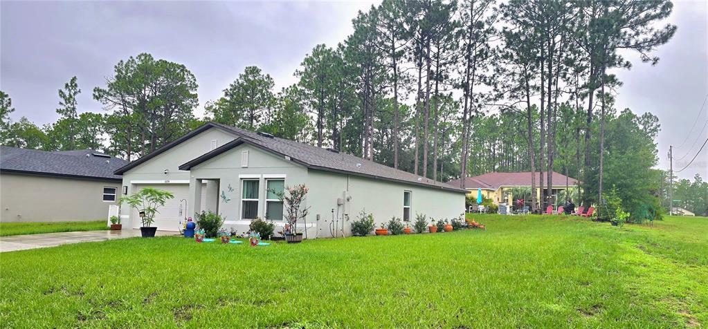 A light-colored, single-story house with a garage and a large grassy yard — 6694 N EDELWEISS WAY, CITRUS SPRINGS, FL