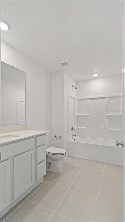 A bathroom features a white vanity, a toilet, and a shower-tub combination with tile flooring — 6280 BOTTICELLA BOULEVARD, WINTER HAVEN, FL