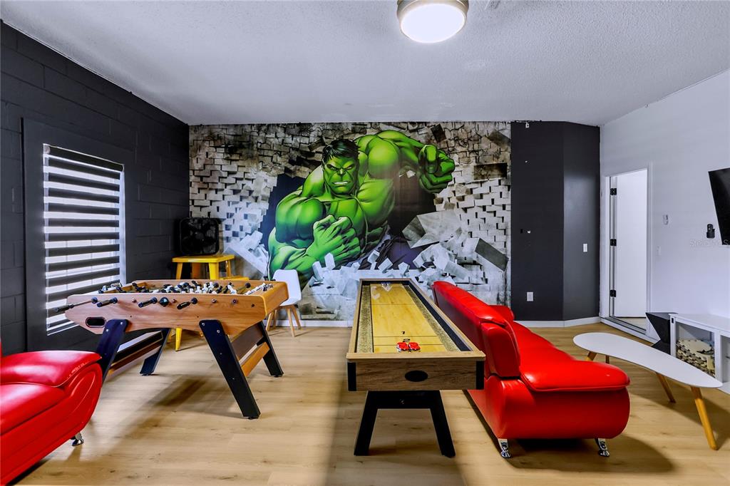 A game room features a Hulk wall mural, a foosball table, a shuffleboard table, and furniture — 186 NAZHA DRIVE, DAVENPORT, FL