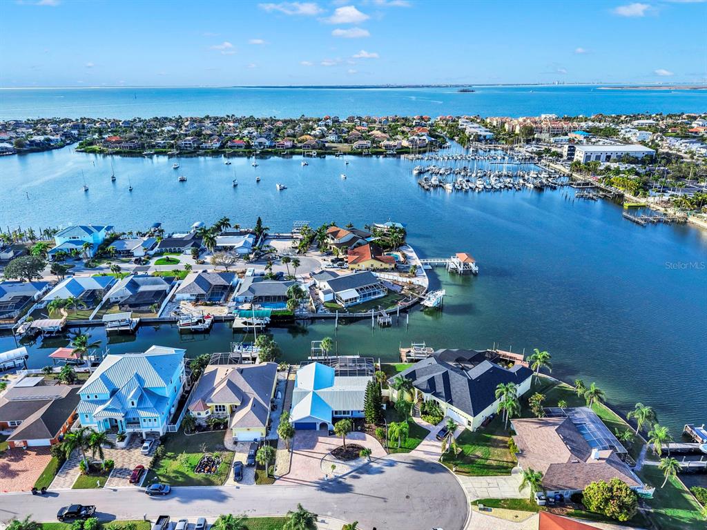 An aerial view shows waterfront homes with docks along a canal leading to the bay — 6344 COTTONWOOD LANE, APOLLO BEACH, FL