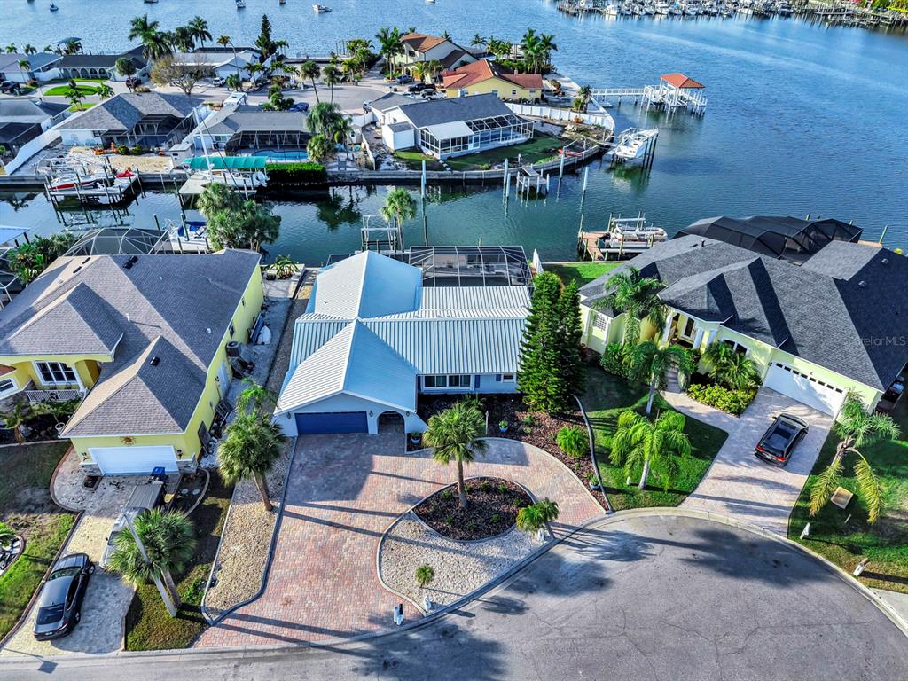 An aerial view shows three waterfront houses with paved driveways and private boat docks — 6344 COTTONWOOD LANE, APOLLO BEACH, FL