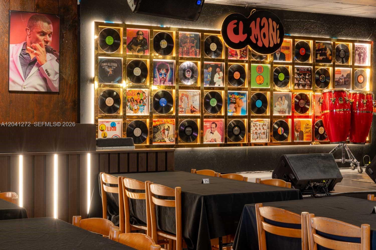 A dining area features tables with black cloths and a wall decorated with vinyl records — 1200 NW 78 Avenue, Miami FL 33126, MIAMI, FL