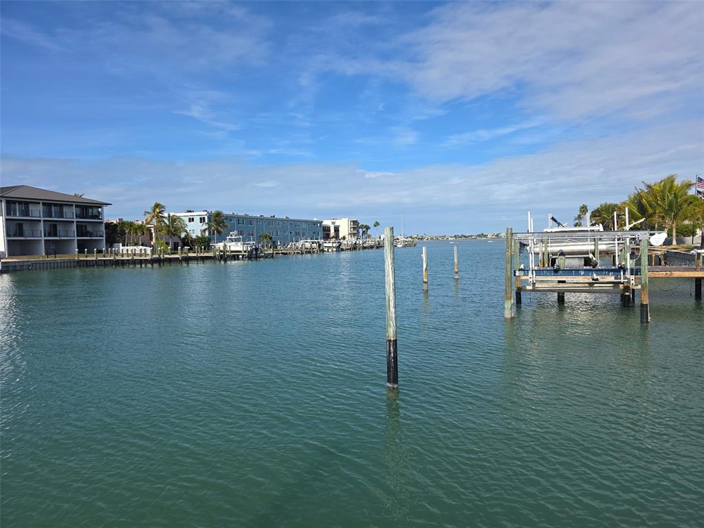 A view of a calm waterway with boat docks, pilings, and waterfront apartment buildings — 12200 4TH STREET E, TREASURE ISLAND, FL