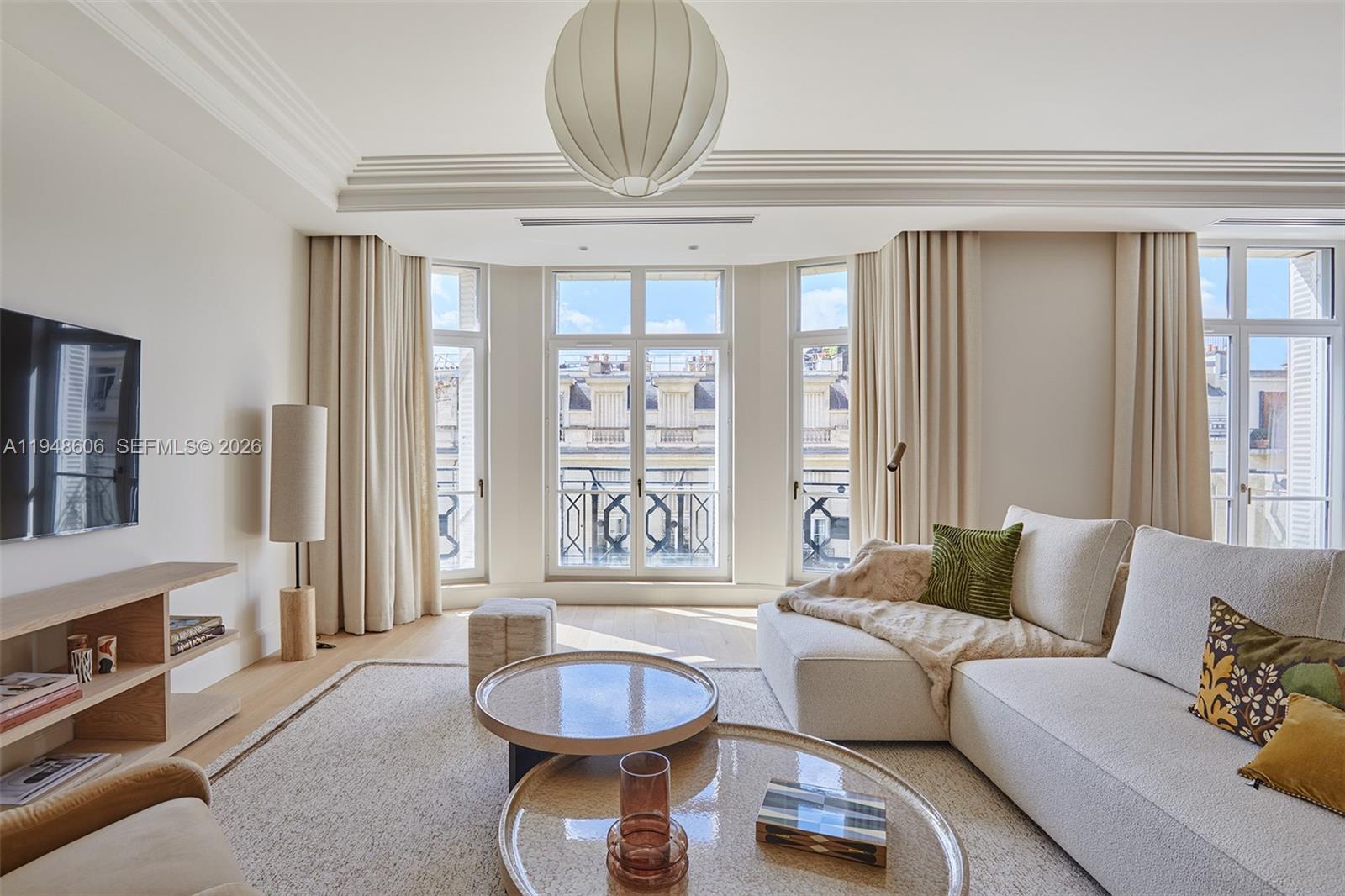 A bright living room features a sectional sofa, two round coffee tables, and large windows — 9 Avenue Frederic Le Play # 401, Fr, Fr