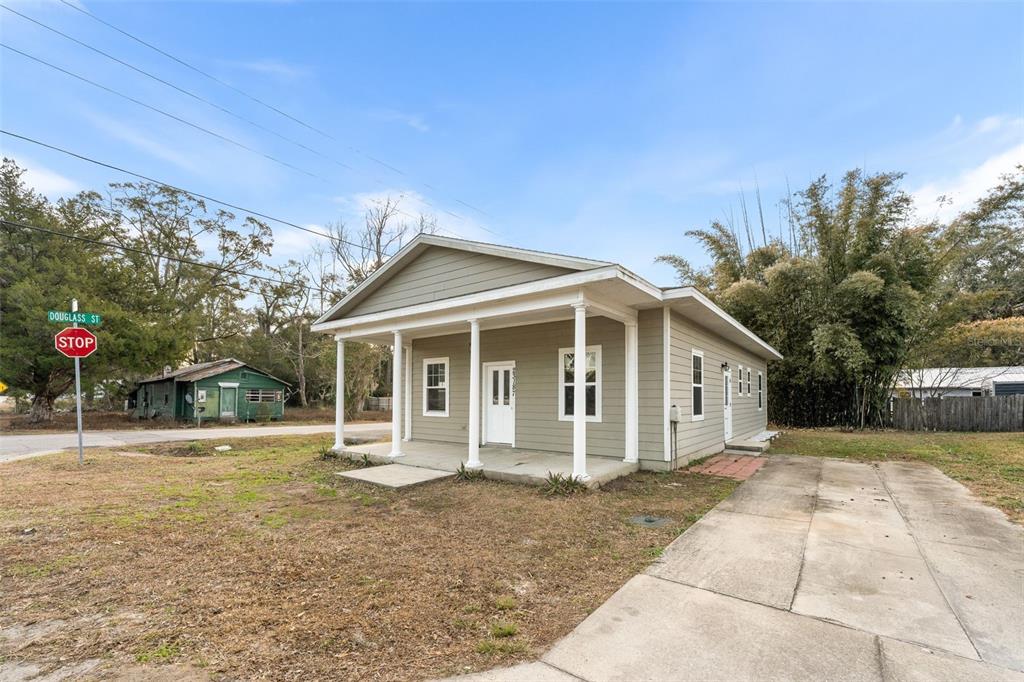 A single-story house with light green siding and a front porch stands on a corner lot — 23187 NW 179 PLACE, HIGH SPRINGS, FL