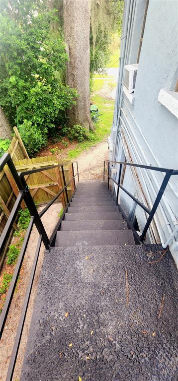 An exterior view looking down a set of metal stairs toward a dirt path — 301 SE AVENUE B UNIT 4, WINTER HAVEN, FL