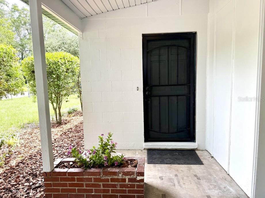 A concrete driveway leads to a covered carport attached to the side of a house — 1507 NE 12TH TERRACE, GAINESVILLE, FL