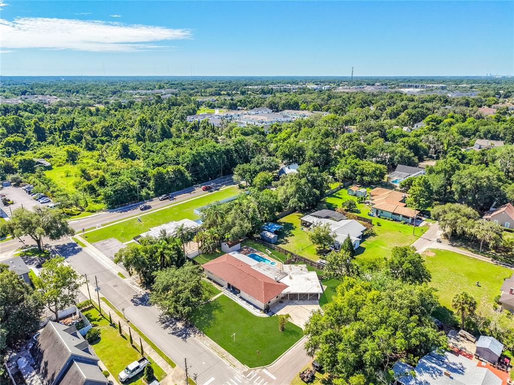 An aerial view shows a residential house with a pool and large yard near roads — 52 CLARK STREET, OVIEDO, FL