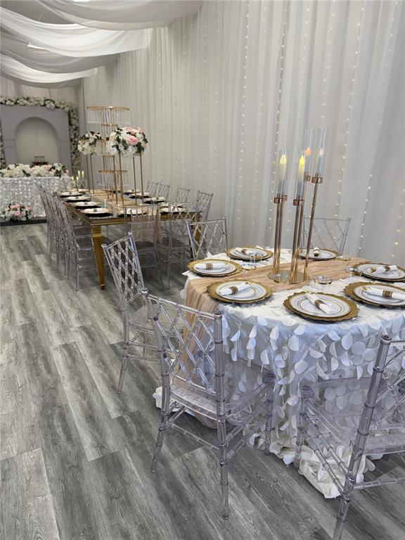 A banquet room features round and rectangular tables with clear chairs and decorative lighting — 1368 NARCOSSEE ROAD, ST CLOUD, FL
