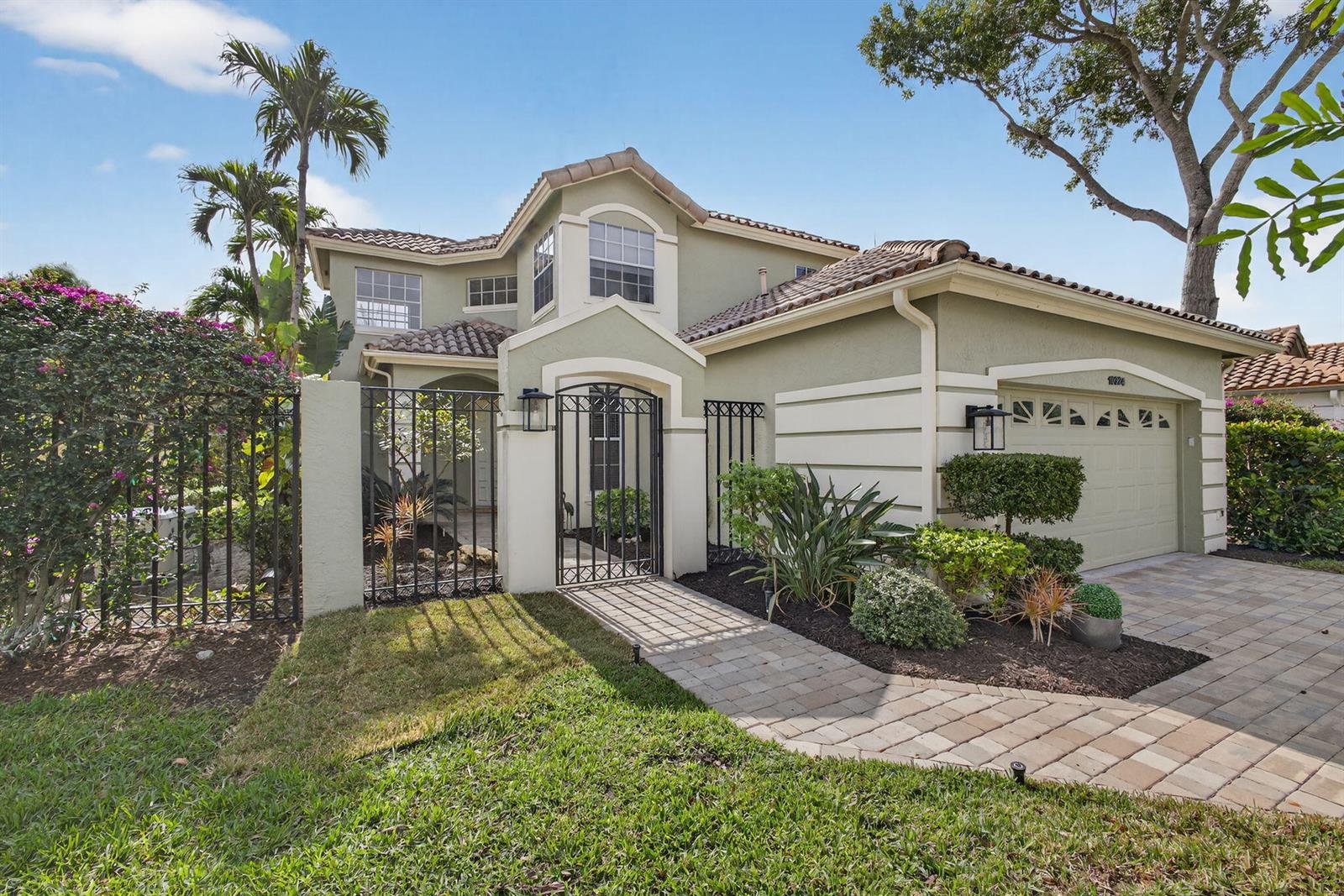 A two-story house with a tiled roof, gated courtyard, and paved driveway — 10324 Osprey Trace, West Palm Beach FL 33412, WEST PALM BEACH, FL