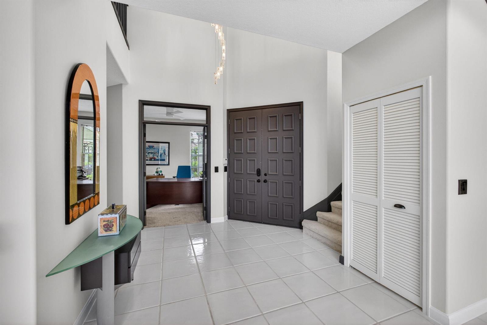 A tiled entryway features a double front door, a staircase, and a glass console table — 10324 Osprey Trace, West Palm Beach FL 33412, WEST PALM BEACH, FL