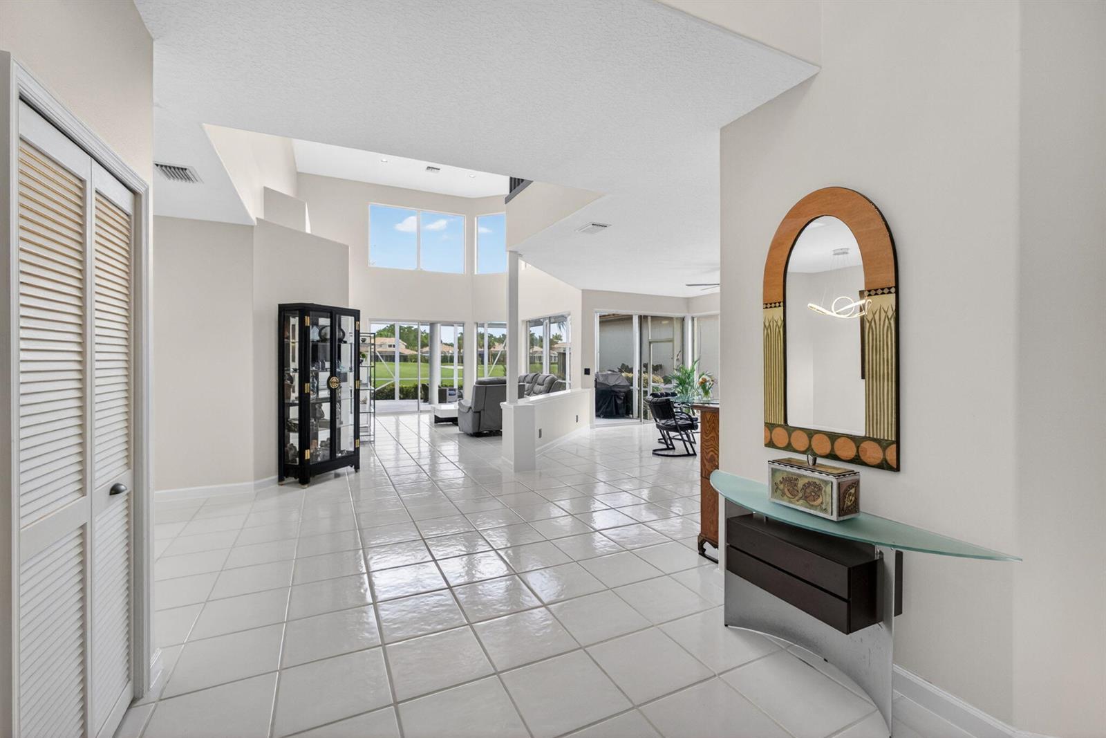 A bright, tiled entryway leads into an open-concept living area with high ceilings and windows — 10324 Osprey Trace, West Palm Beach FL 33412, WEST PALM BEACH, FL