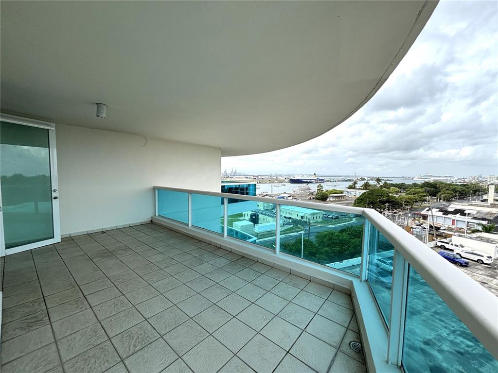 A tiled balcony with a glass railing overlooks a harbor with ships and buildings — 550 Avenida Constitucion AVENIDA CONSTITUCION UNIT 901, SAN JUAN, PR