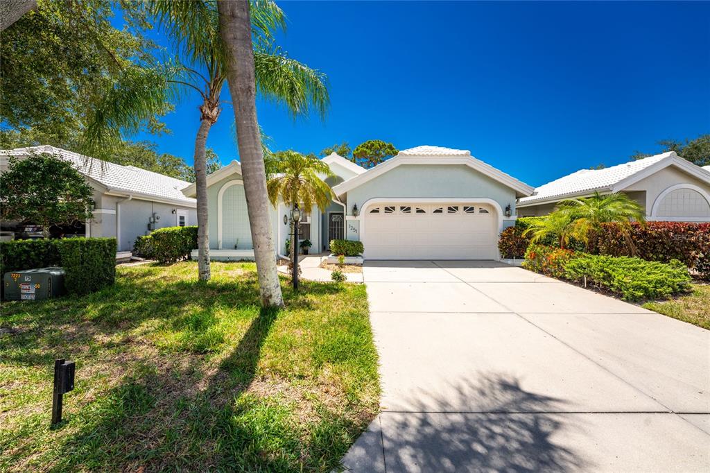 A covered patio overlooks a small swimming pool with a fountain against a blue wall — 1251 HARBOR TOWN WAY, VENICE, FL