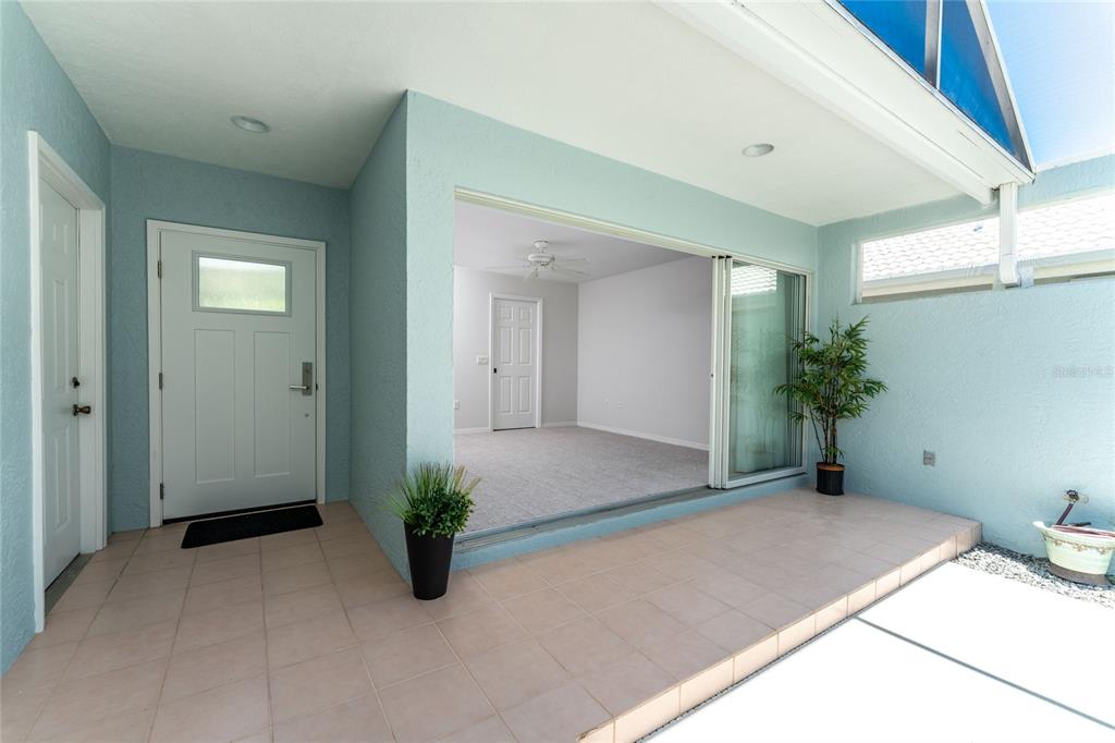A screened-in patio features a small swimming pool, light blue walls, and tiled flooring — 1251 HARBOR TOWN WAY, VENICE, FL