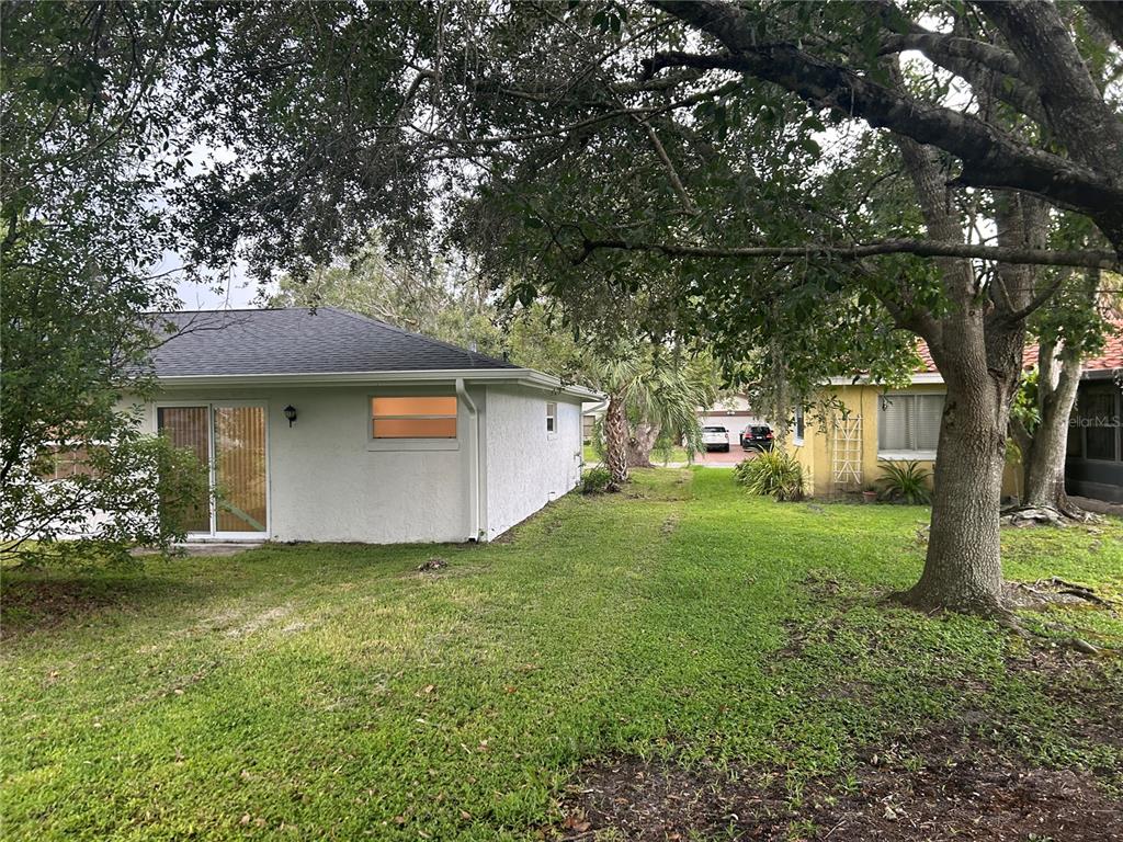 A white house with a sliding glass door sits next to a yellow house — 620 MIDIRON DRIVE, KISSIMMEE, FL