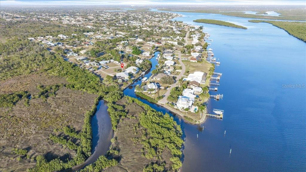 An aerial view shows waterfront homes situated along a canal surrounded by dense vegetation — 3712 BALBOA COURT, PUNTA GORDA, FL
