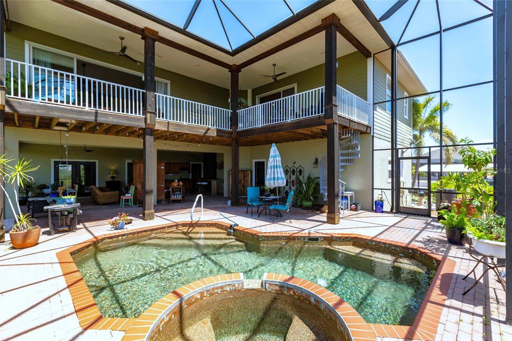 A two-story house features a screened-in patio with a pool and an attached hot tub — 3712 BALBOA COURT, PUNTA GORDA, FL