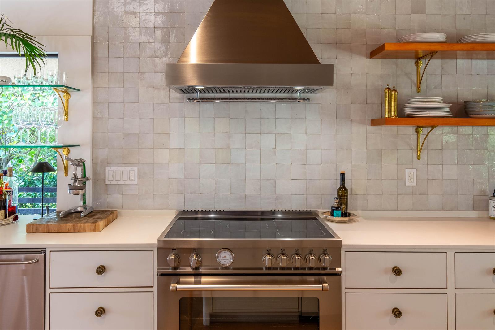 A kitchen features a stainless steel range, a matching hood, and light-colored square wall tiles — 11669 Wimbledon Circle, Wellington FL 33414, WELLINGTON, FL