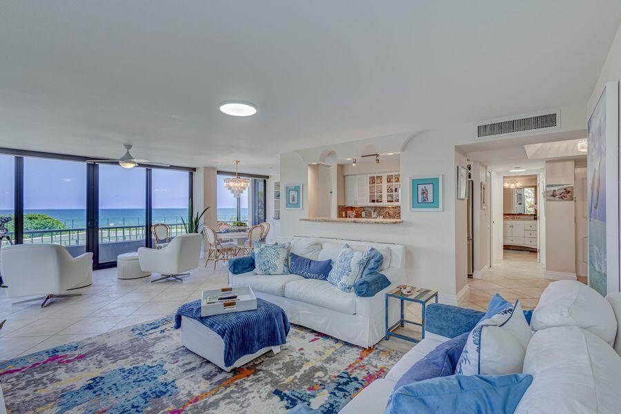 A bright living room features white furniture, a patterned area rug, and ocean views — 5550 N Ocean Drive # 3c, Riviera Beach FL 33404, RIVIERA BEACH, FL
