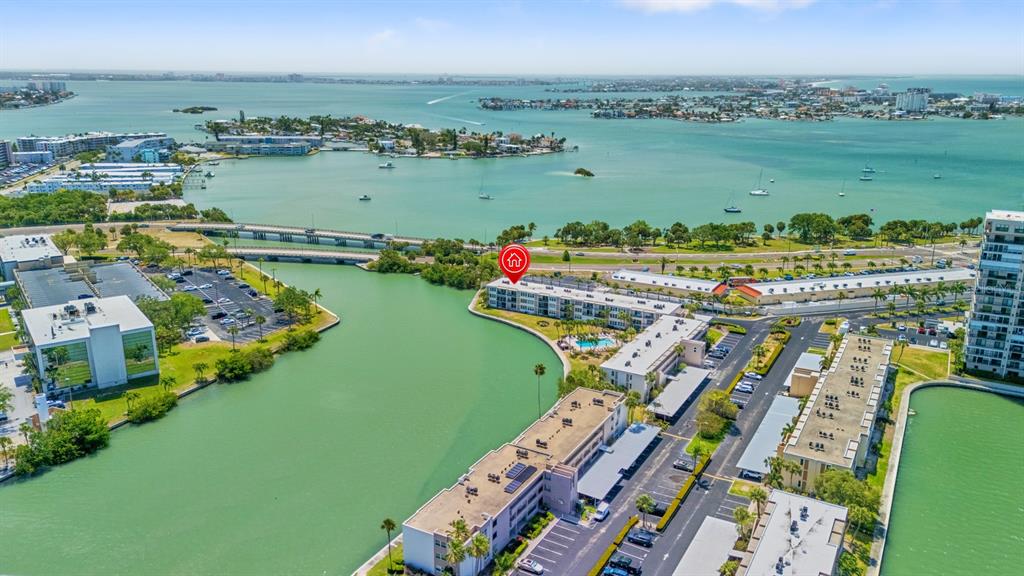 An aerial view shows waterfront apartment buildings with a swimming pool and parking lots — 7401 BAY ISLAND DRIVE S UNIT 337, SOUTH PASADENA, FL