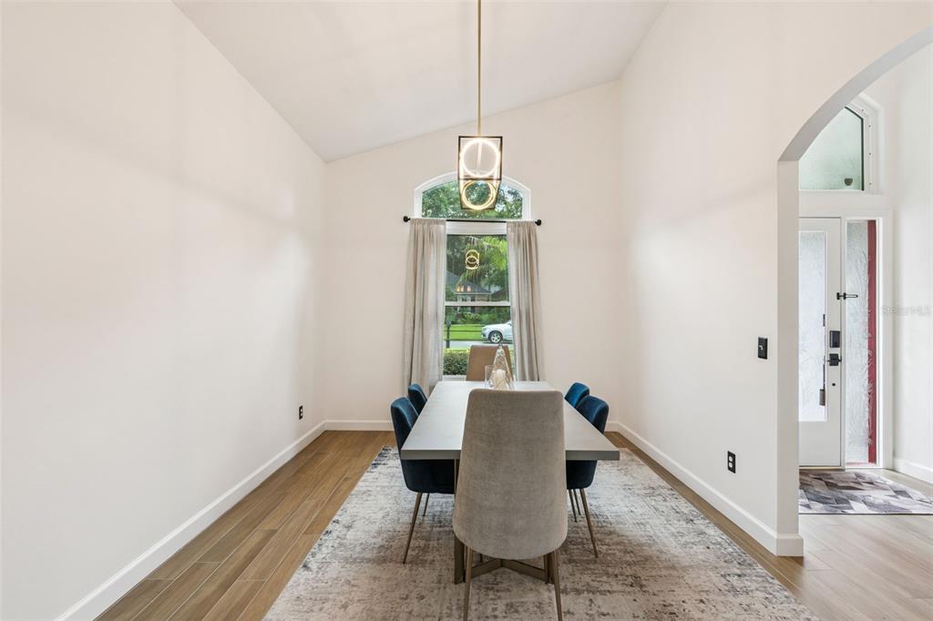 A dining room features a rectangular table, blue chairs, a pendant light, and wood flooring — 2331 RIDGESIDE ROAD, APOPKA, FL