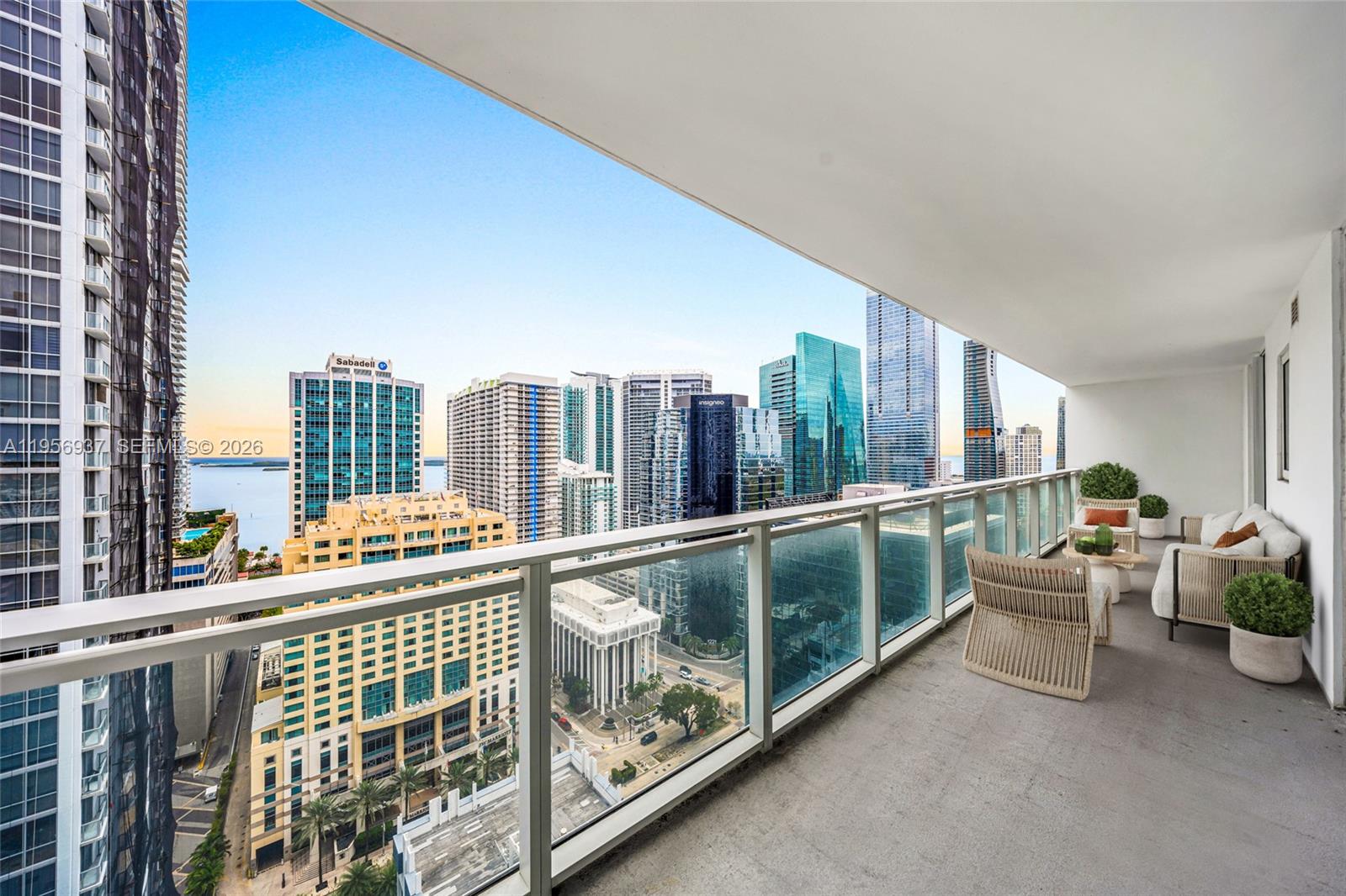A high-rise balcony features outdoor seating and a panoramic view of a city skyline — 1080 Brickell Ave # 2708, Miami FL 33131, MIAMI, FL