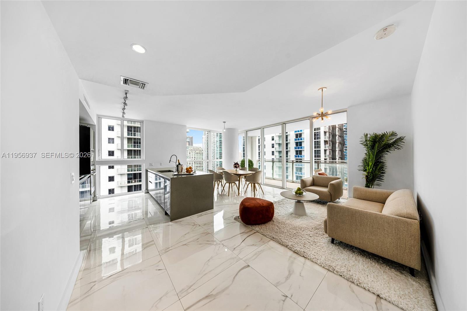A modern open-concept living and dining area features marble tile floors and floor-to-ceiling windows — 1080 Brickell Ave # 2708, Miami FL 33131, MIAMI, FL