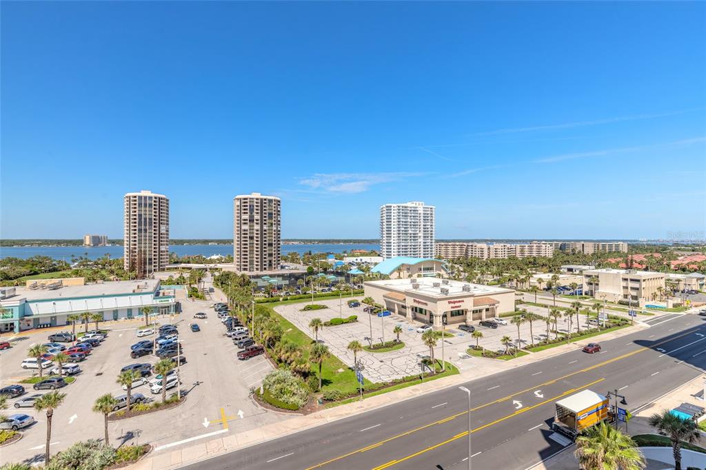 An aerial view shows a parking lot, a Walgreens store, and high-rise buildings near water — 3023 S ATLANTIC AVENUE UNIT 9010, DAYTONA BEACH, FL