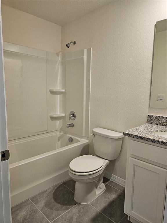 A bathroom features a white tub-shower combo, a toilet, and a granite-topped vanity — 2926 HUDSON HAMMOCK WAY, BEND, HARMONY, FL