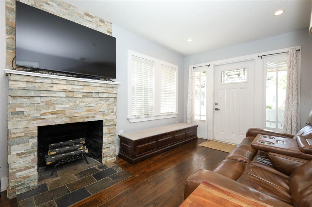 A living room features a stone fireplace, a built-in bench, and a brown leather sofa — 1419 CANTON STREET, ORLANDO, FL