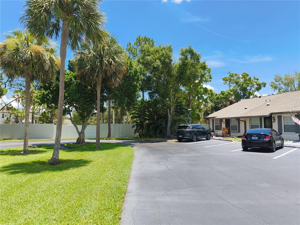 An empty room with wood-look flooring, white walls, a sliding glass door, and a chandelier — 3962 LA COSTA LANE, LARGO, FL