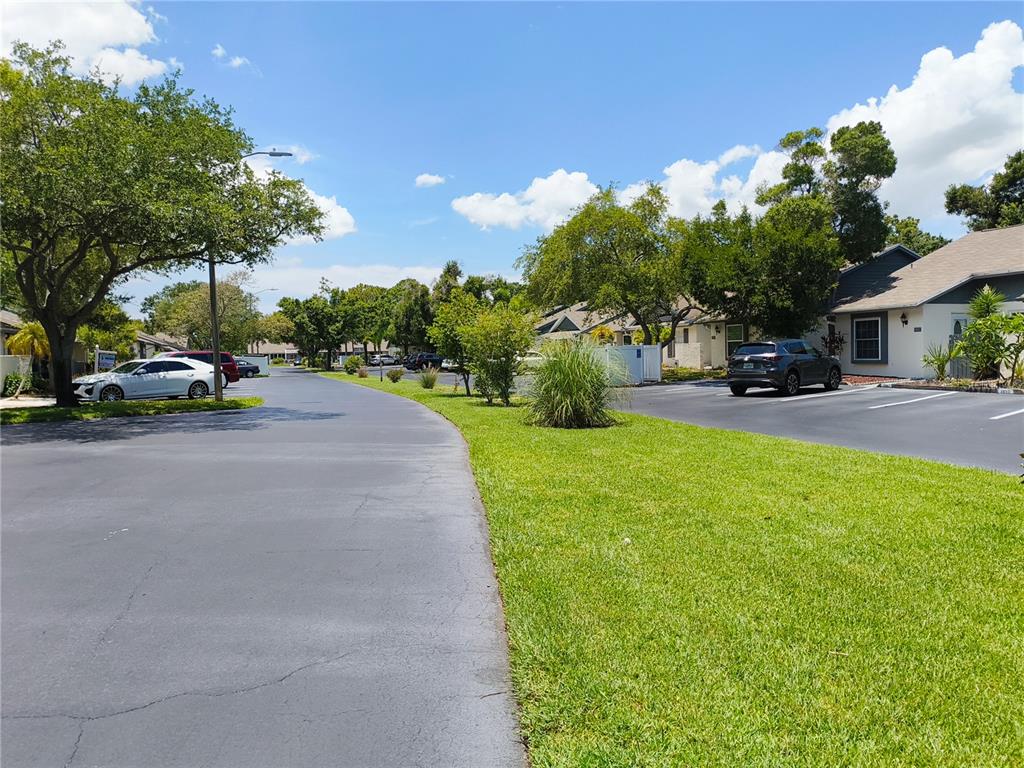 A kitchen features wood-grain cabinets, white appliances, and a large window with blinds — 3962 LA COSTA LANE, LARGO, FL