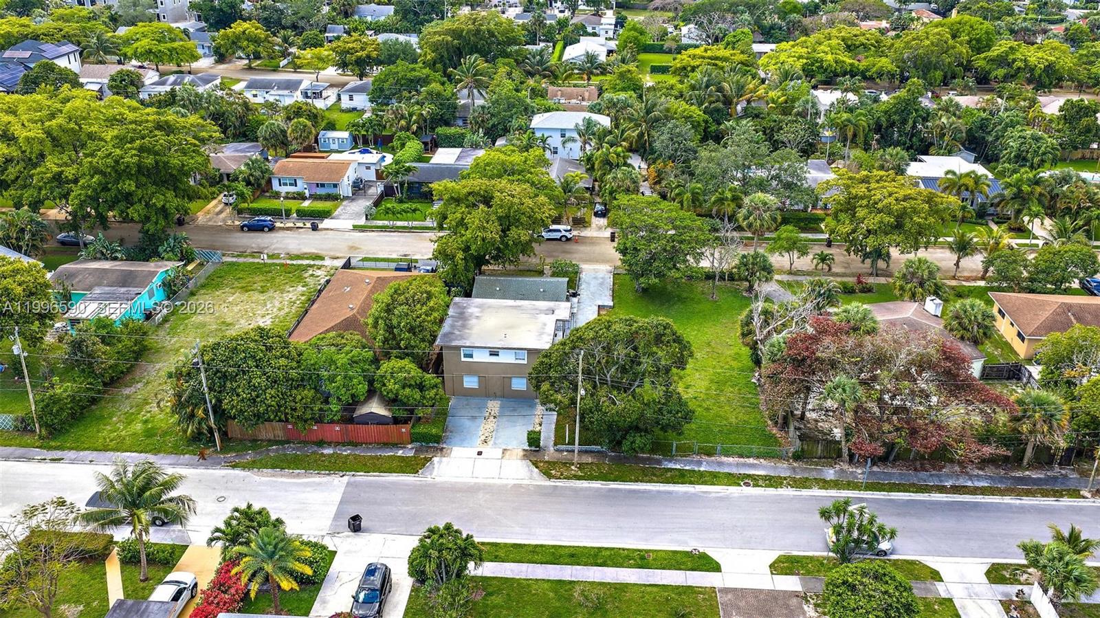 An aerial view shows a two-story house with a driveway surrounded by trees and lawns — 940 Charles St, West Palm Beach FL 33401, WEST PALM BEACH, FL