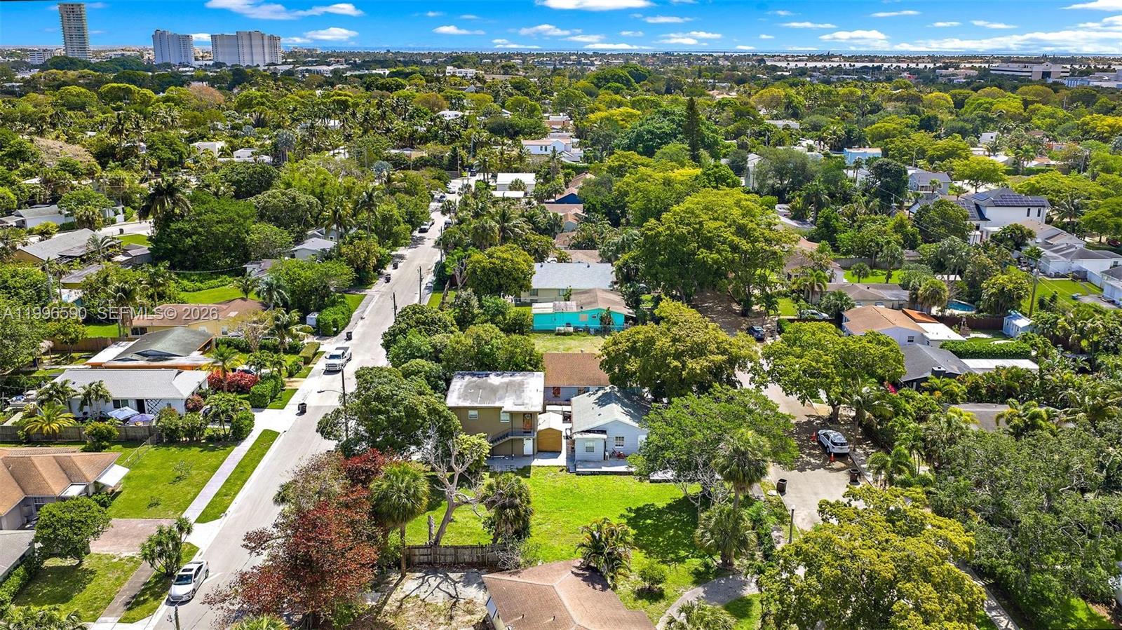 An aerial view shows a residential neighborhood with houses, lush trees, and paved streets — 940 Charles St, West Palm Beach FL 33401, WEST PALM BEACH, FL