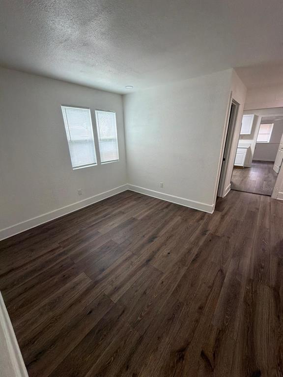 A bedroom features a bed with neutral bedding, a ceiling fan, and wood-look flooring — 233 S RHODES STREET, MOUNT DORA, FL
