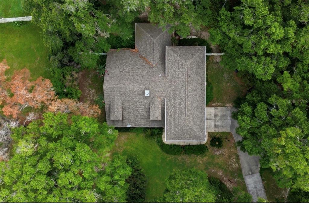 An aerial view shows a house with a shingled roof surrounded by trees and grass — 4370 SE 26TH TERRACE ROAD, OCALA, FL