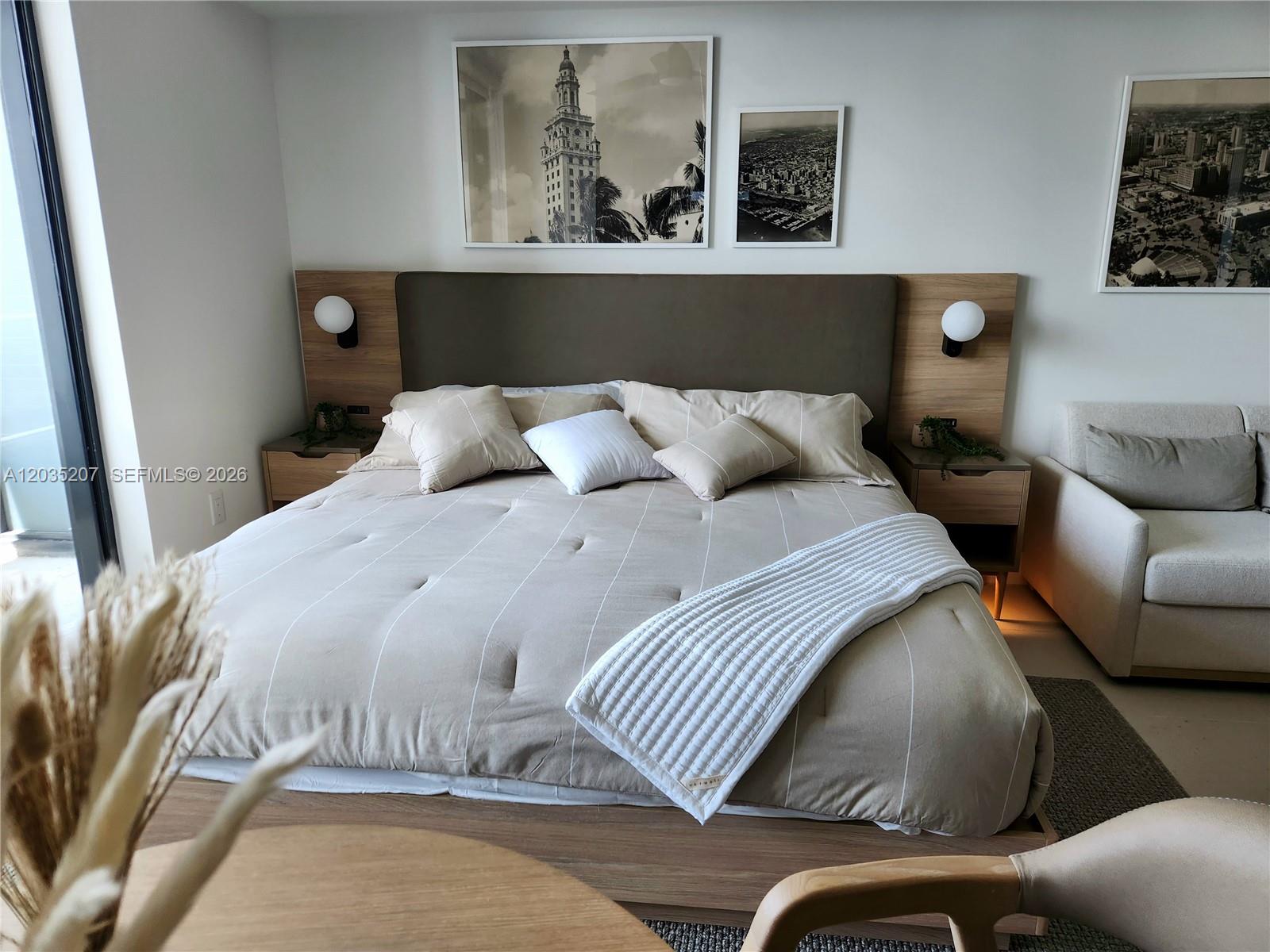 A bedroom features a platform bed with a large headboard, bedside tables, and wall art — 601 NE 1 AVE # 2812, Miami FL 33132, MIAMI, FL
