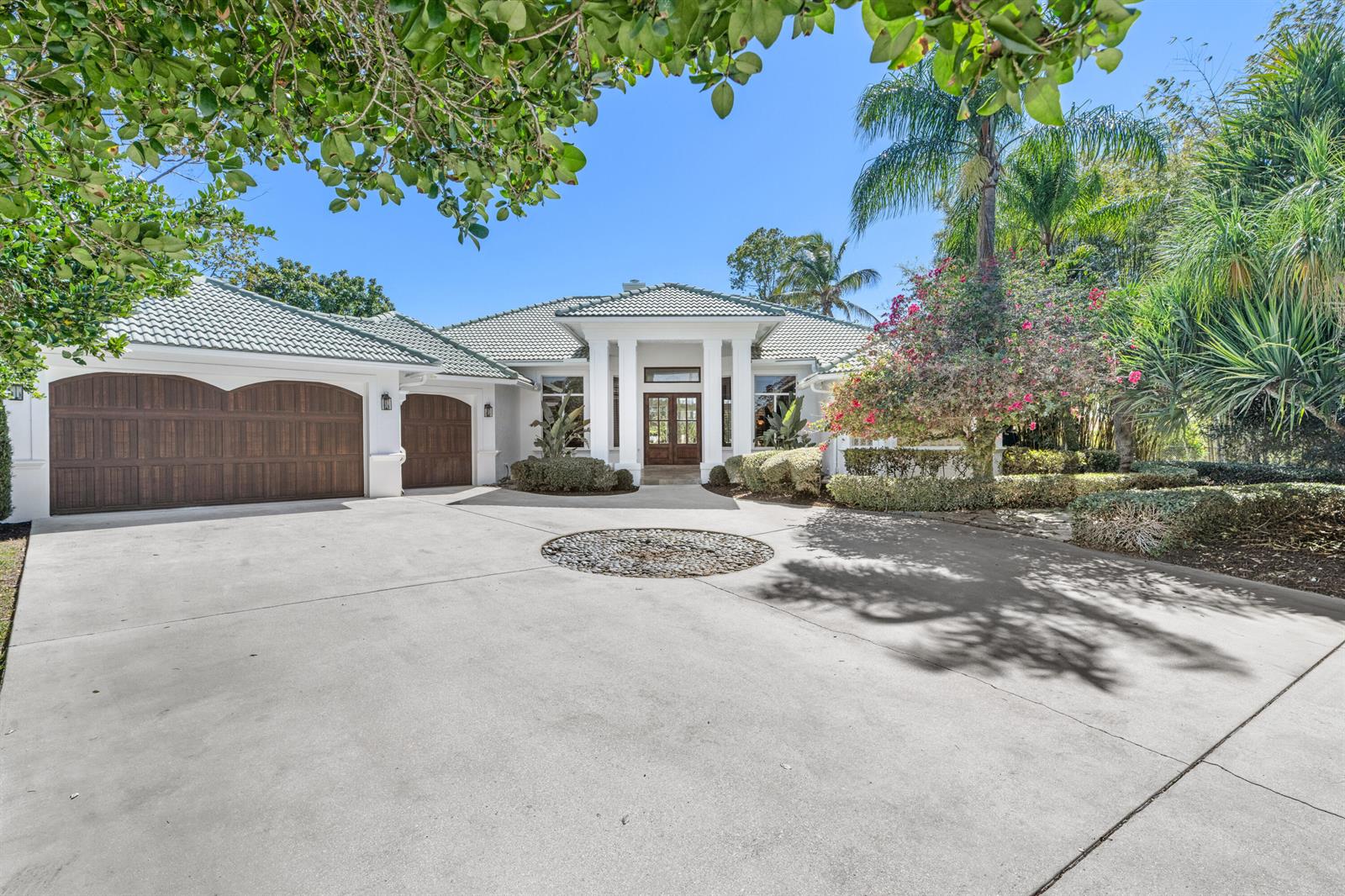 A single-story house with a white exterior, tile roof, and a large concrete driveway — 15390 Take Off Place, Wellington FL 33414, WELLINGTON, FL