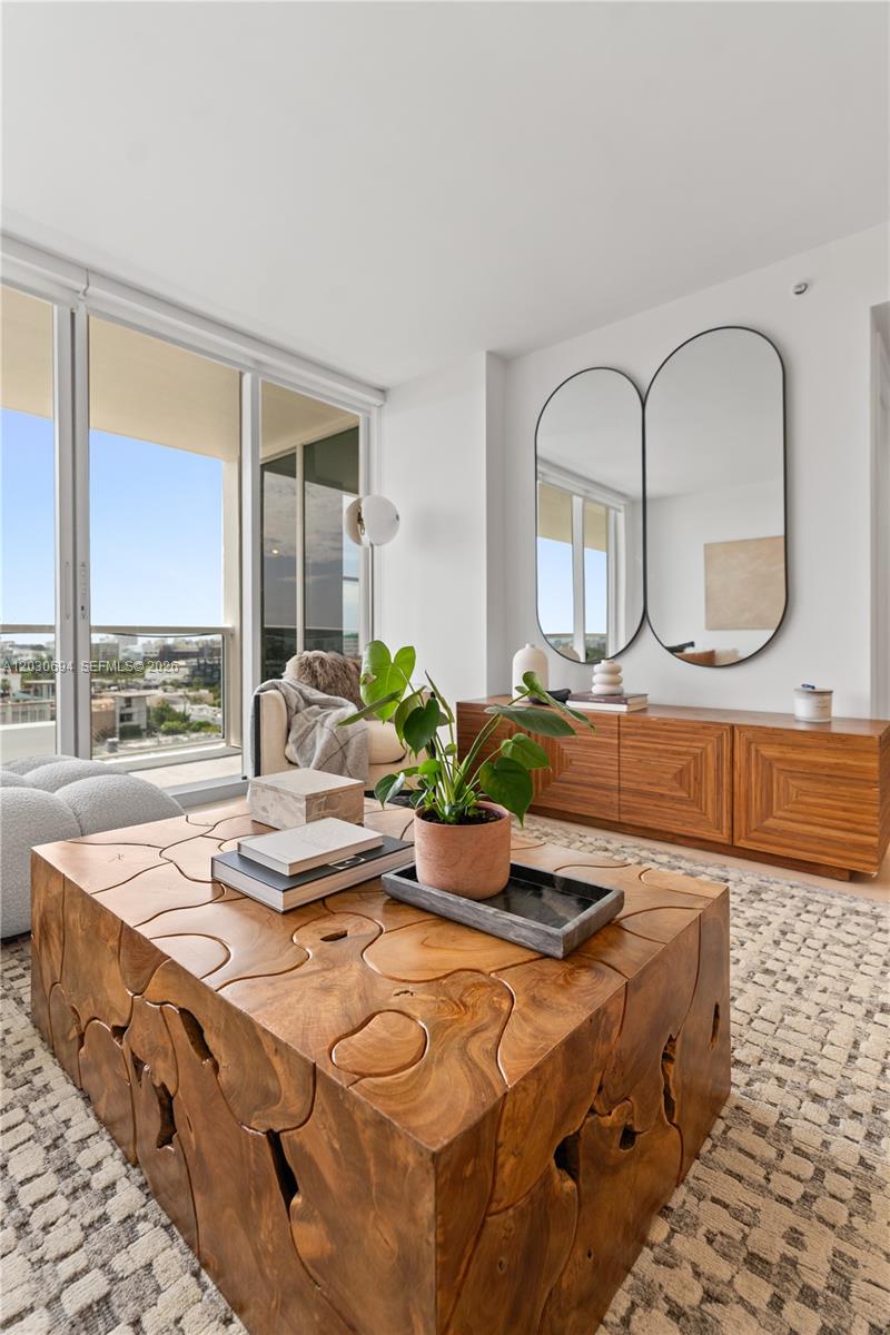 A living room features a carved wooden coffee table, a console, and two oval mirrors — 1800 Sunset Harbour Dr # 1003, Miami Beach FL 33139, MIAMI BEACH, FL