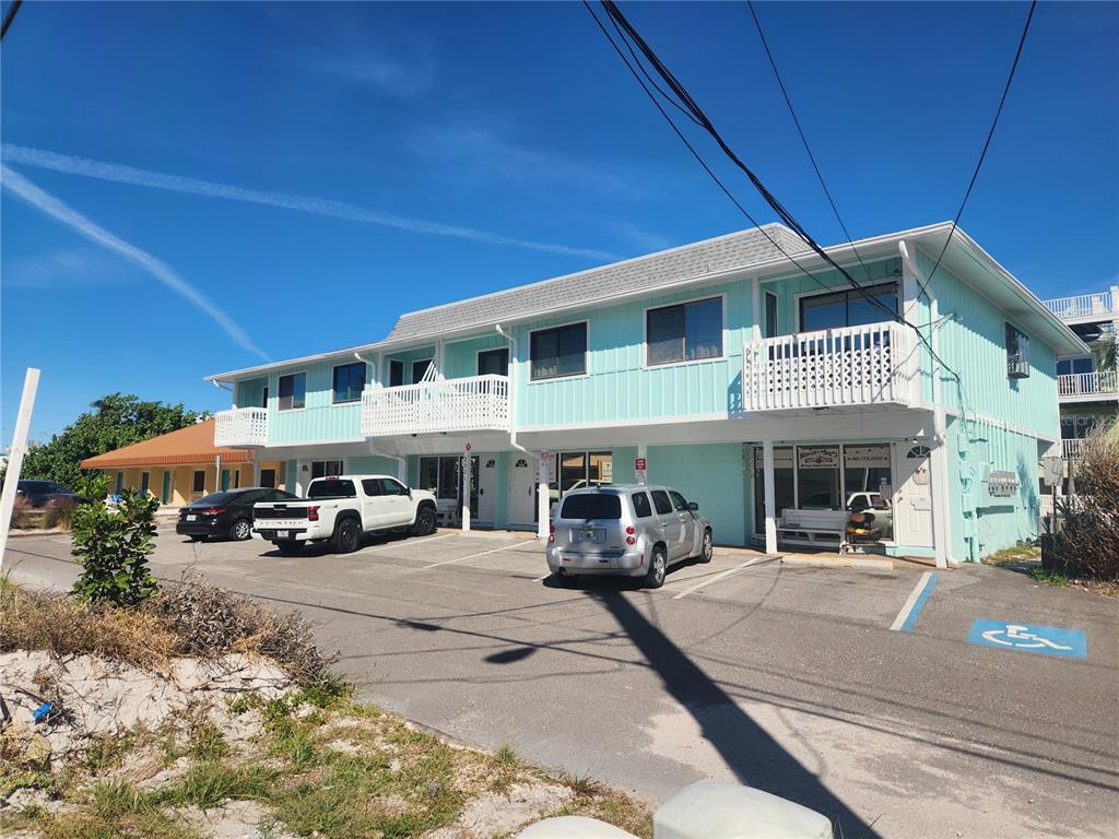 A two-story light blue building with a parking lot and a handicap-accessible parking space — 2501 GULF DRIVE N UNIT 103, BRADENTON BEACH, FL