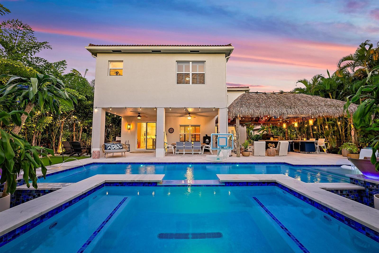 A two-story house exterior features a backyard pool, a tiki bar, and a covered patio — 152 Porgee Rock Place, Jupiter FL 33458, JUPITER, FL