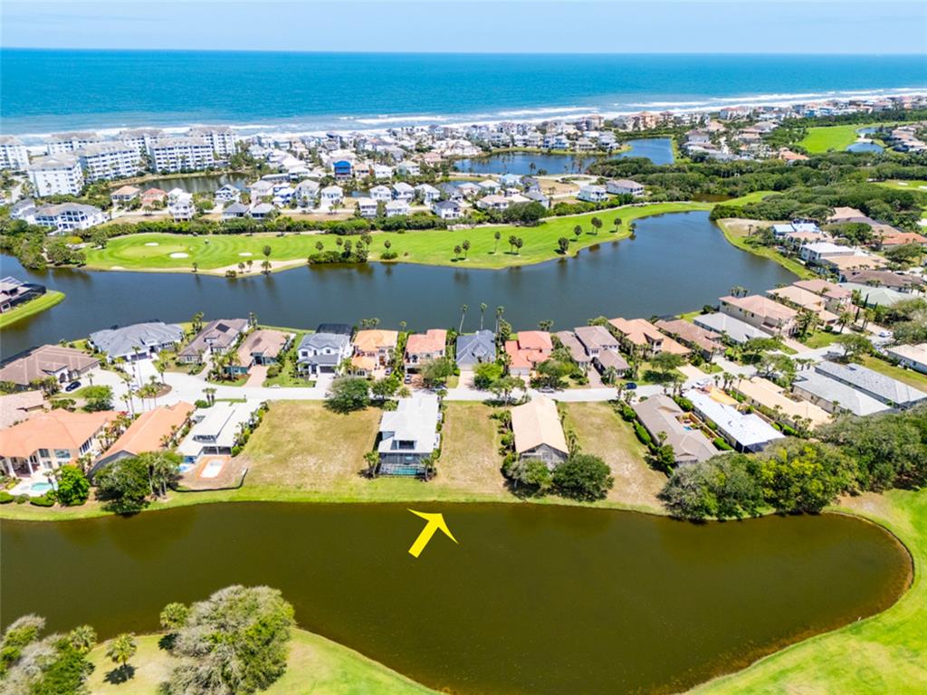 An aerial view shows a row of houses situated along a lake near the coast — 51 KINGFISHER LANE, PALM COAST, FL