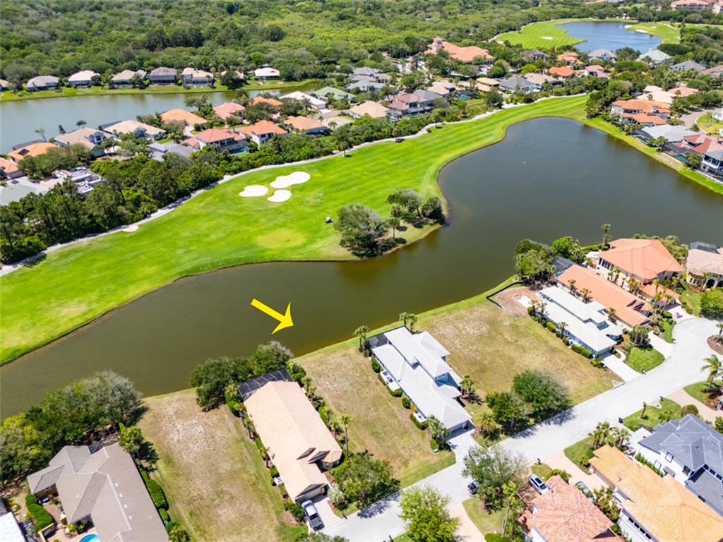 An aerial view shows a residential neighborhood with houses bordering a golf course and lake — 51 KINGFISHER LANE, PALM COAST, FL
