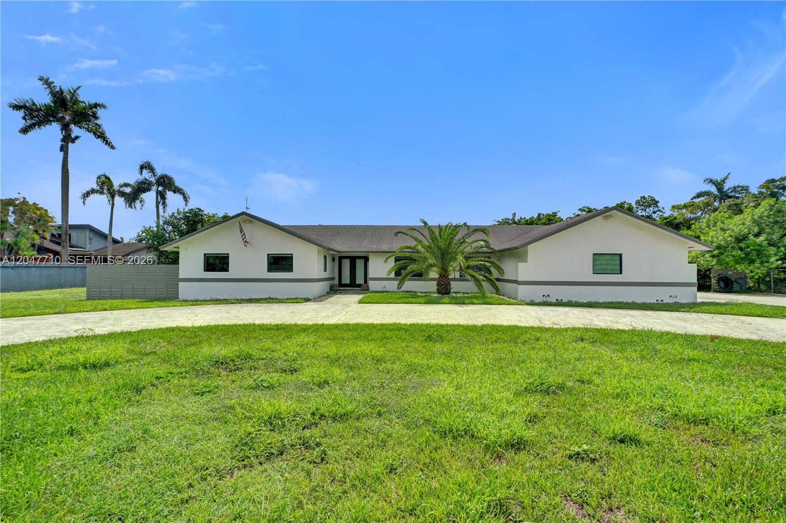 A single-story white house with a palm tree sits behind a large grassy lawn — 22421 SW 184th Ave, Miami FL 33170, MIAMI, FL