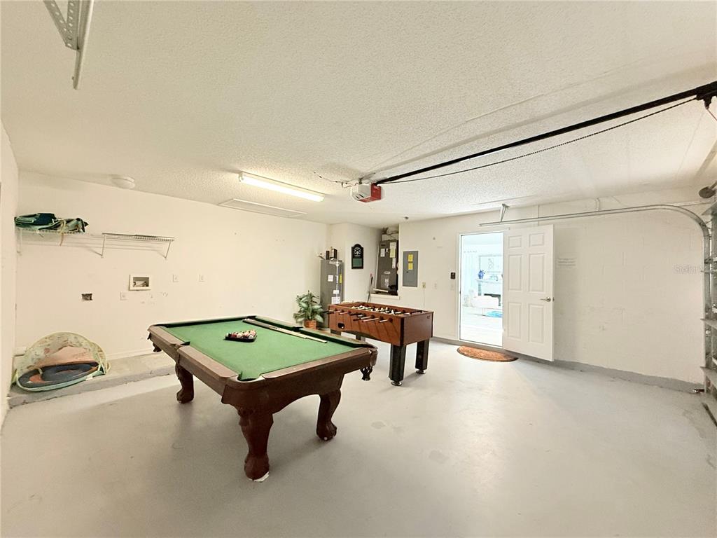 A garage converted into a game room with a pool table and foosball table — 8587 SUNRISE KEY DRIVE, KISSIMMEE, FL