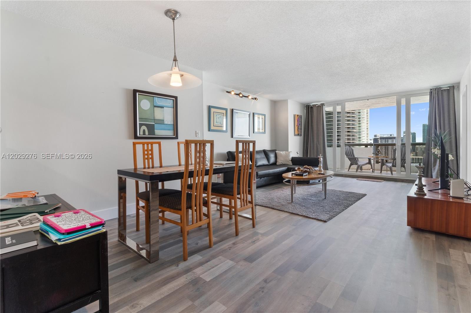 A living and dining room with wood-look flooring, a balcony, and modern furniture — 1717 N Bayshore Dr # 2837, Miami FL 33132, MIAMI, FL